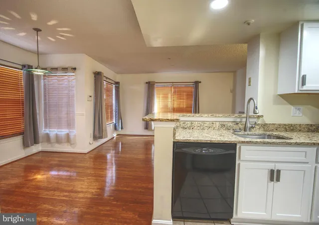 a bathroom with a granite countertop sink a mirror and a shower