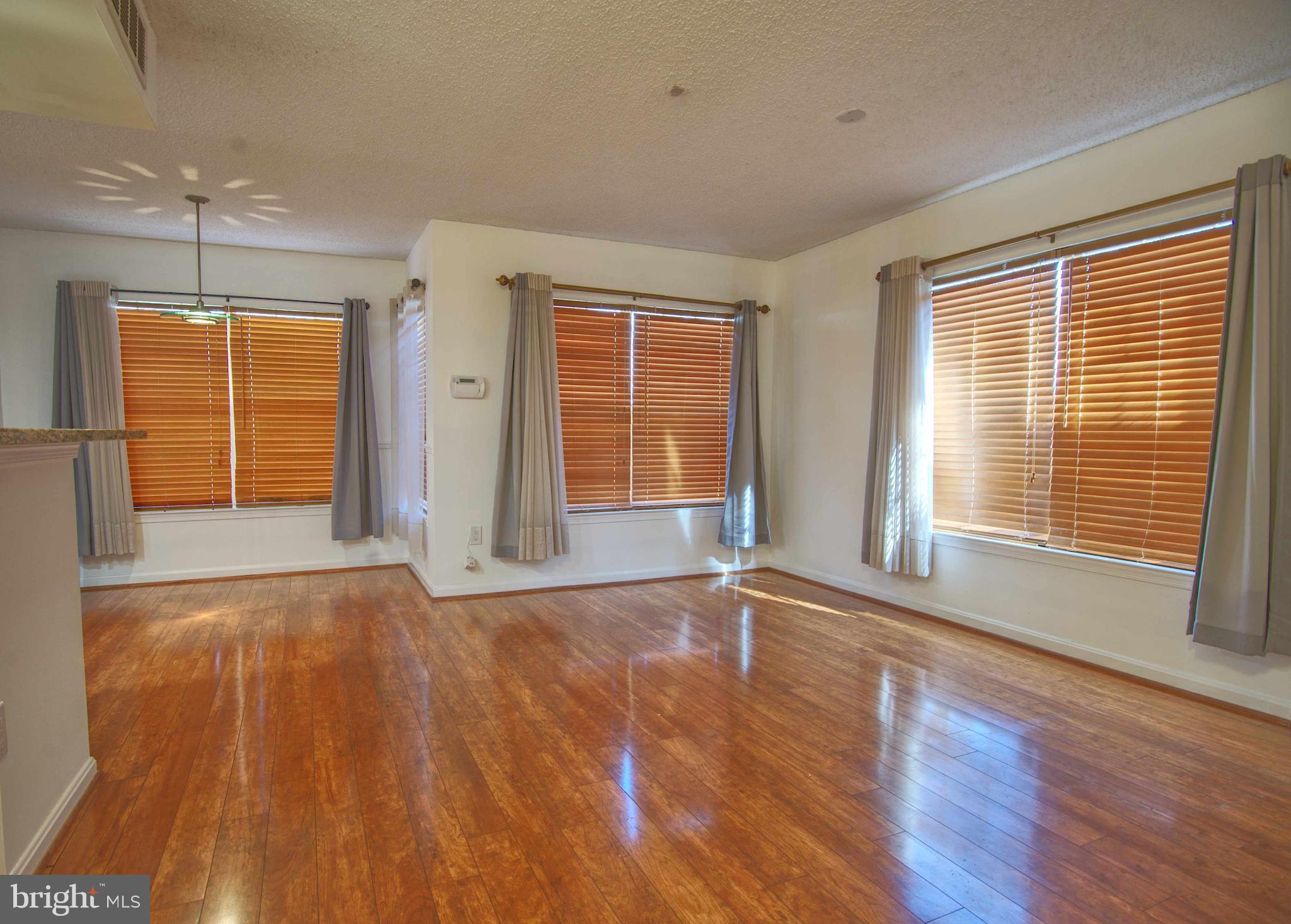 1007 Fallcrest Court, Unit 4104 Bowie, MD 20721 - Photo 21 of 22 a view of an empty room with a window and wooden floor