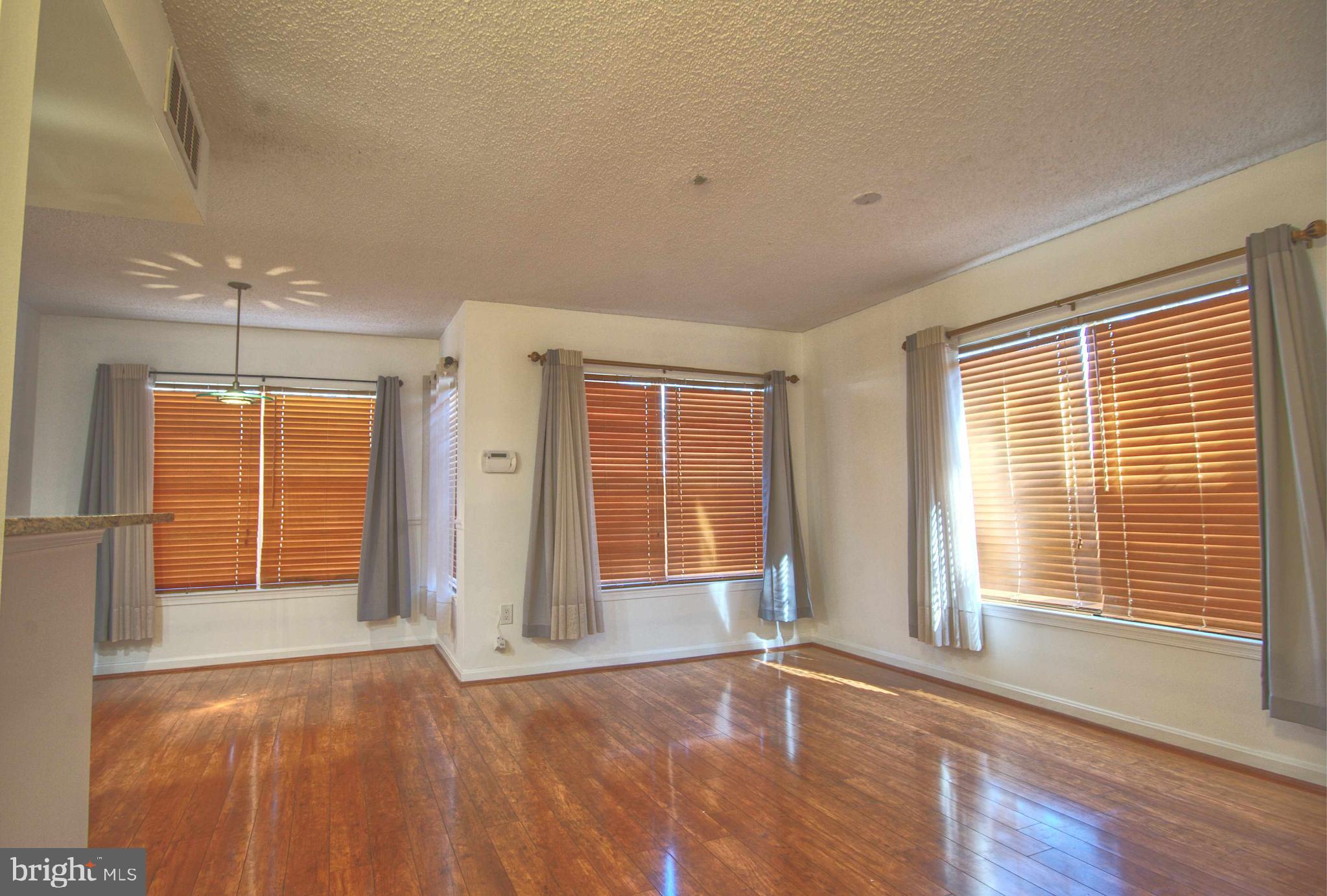 1007 Fallcrest Court, Unit 4104 Bowie, MD 20721 - Photo 22 of 22 a view of an empty room with a window and wooden floor