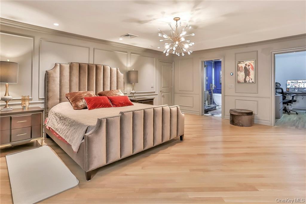 433 New Rochelle Road Bronxville, NY 10708 - Photo 20 of 41 a large bed sitting in a room next to a chandelier
