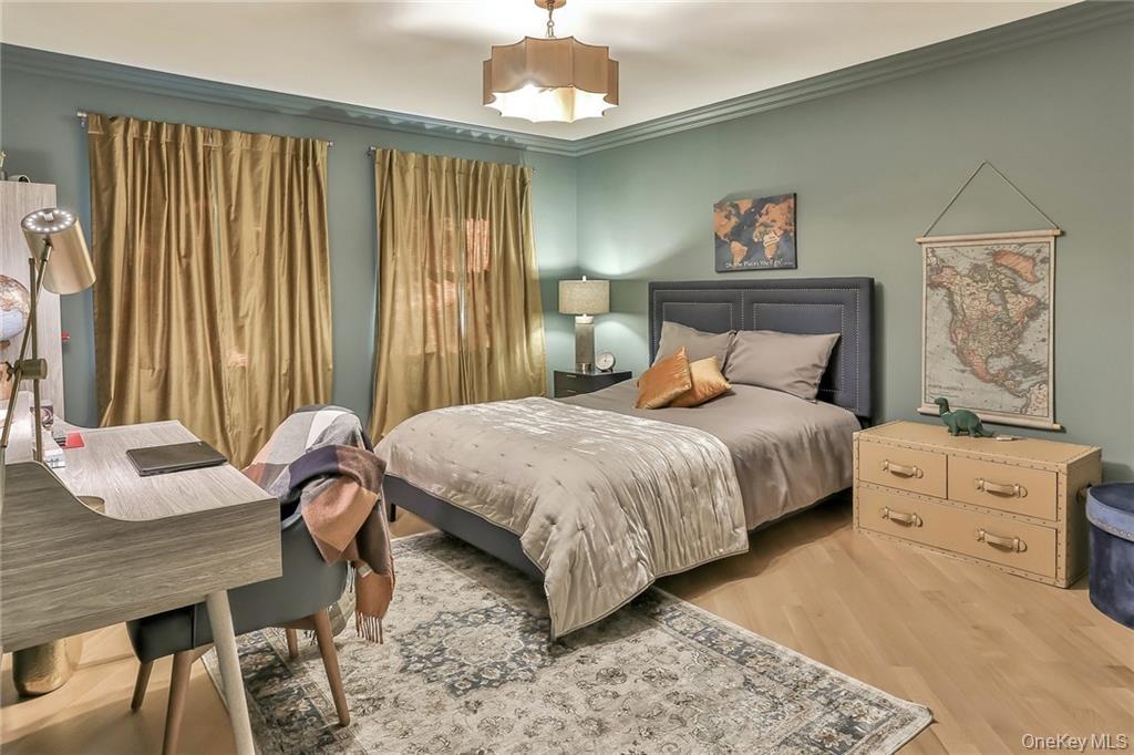 433 New Rochelle Road Bronxville, NY 10708 - Photo 23 of 41 a bedroom with a bed and a chandelier