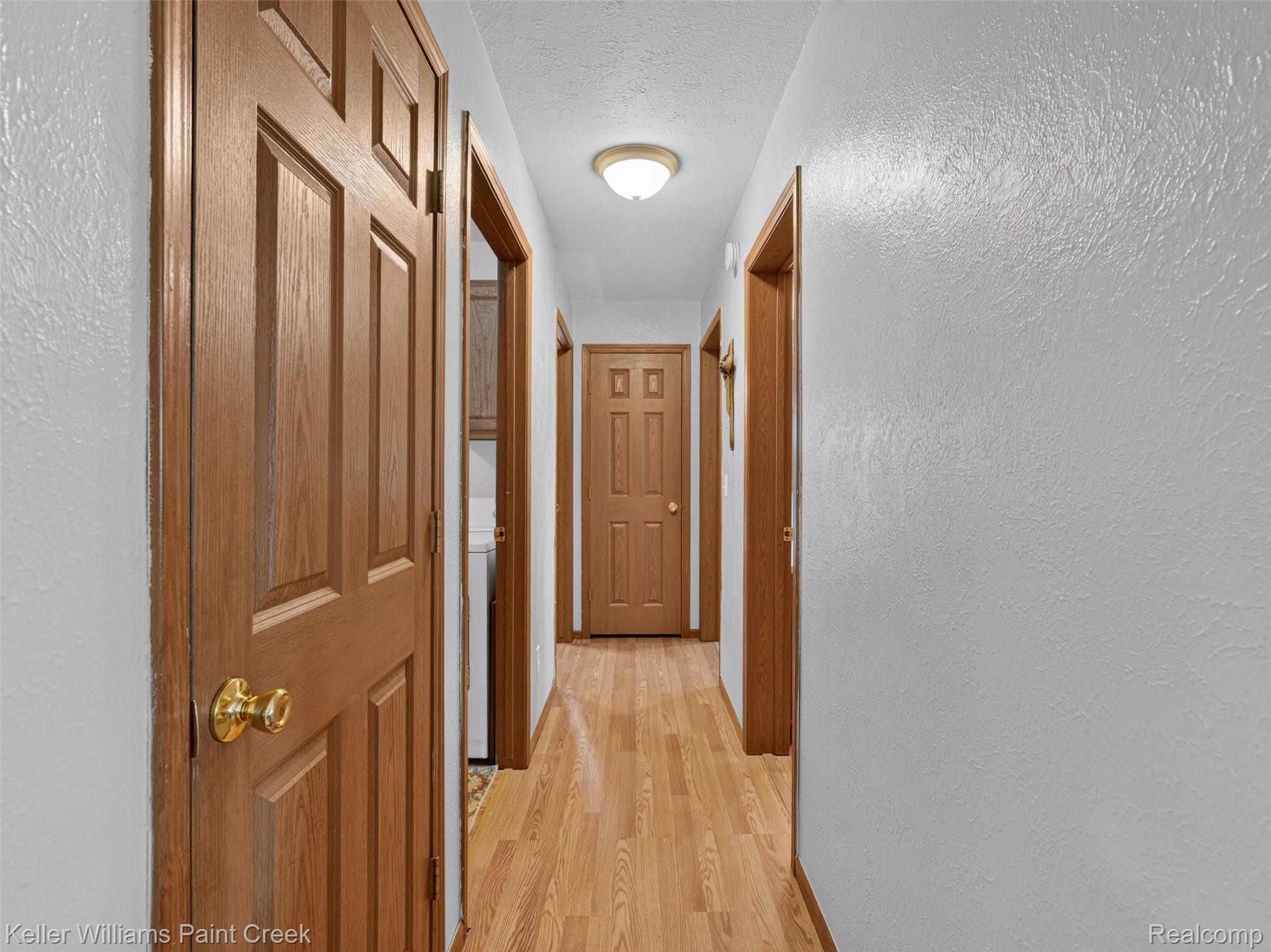 533 White Road Gladwin, MI 48624 - Photo 18 of 69 Dual vanities with white oval sinks, wood-finish cabinetry, and a light-toned countertop