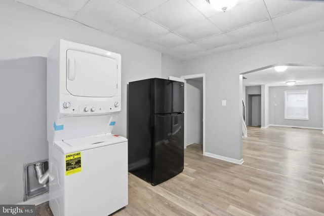 a kitchen with a refrigerator and a wooden floor