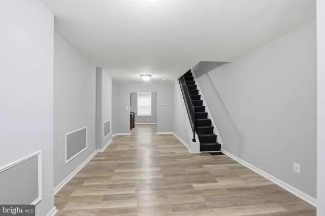a view of hallway with stairs and wooden floor