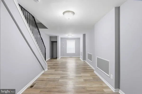 a view of a hallway with wooden floor and staircase
