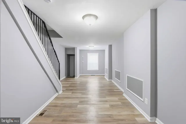 a view of a hallway with wooden floor and staircase