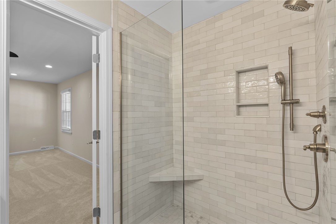 3513 Hopewell Road Anderson, SC 29621 - Photo 2 of 50 Modern shower design, featuring crisp white subway tile and convenient built-in shelving.