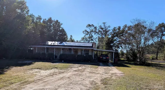 a front view of house with yard and trees in the background