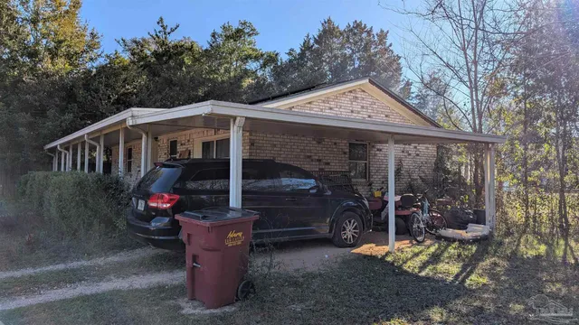 a view of a small house with yard and sitting area