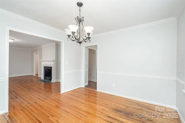 a view of a livingroom with wooden floor and a chandelier