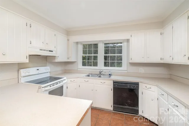 a kitchen with cabinets appliances a sink and a counter space