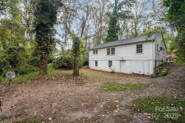 a view of a house with a yard and large trees