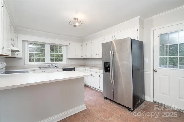 a kitchen with a refrigerator sink and cabinets