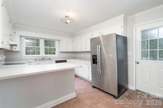 a kitchen with a refrigerator sink and cabinets