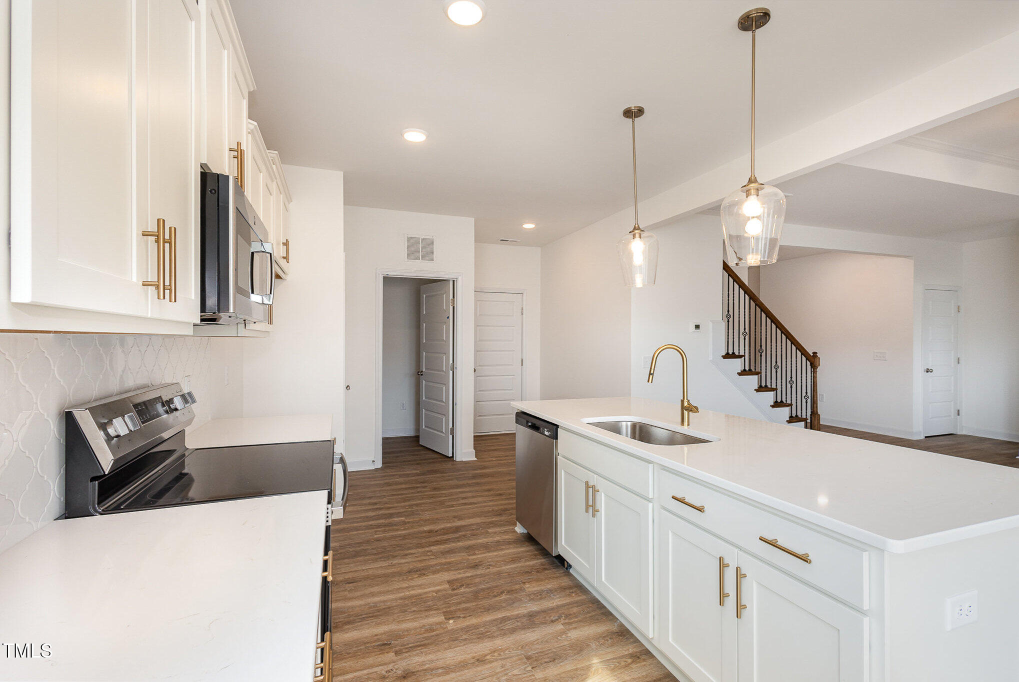 231 Trescott Street Smithfield, NC 27577 - Photo 11 of 28 a large white kitchen with a sink a refrigerator and a stove top oven