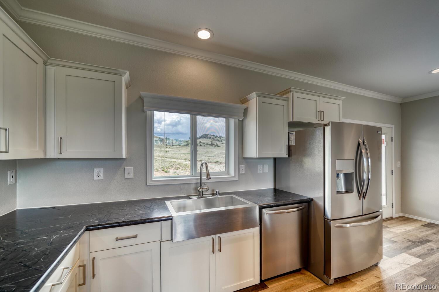 262 Cohonina Road Hartsel, CO 80449 - Photo 7 of 22 a kitchen with kitchen island granite countertop a sink appliances cabinets and counter space