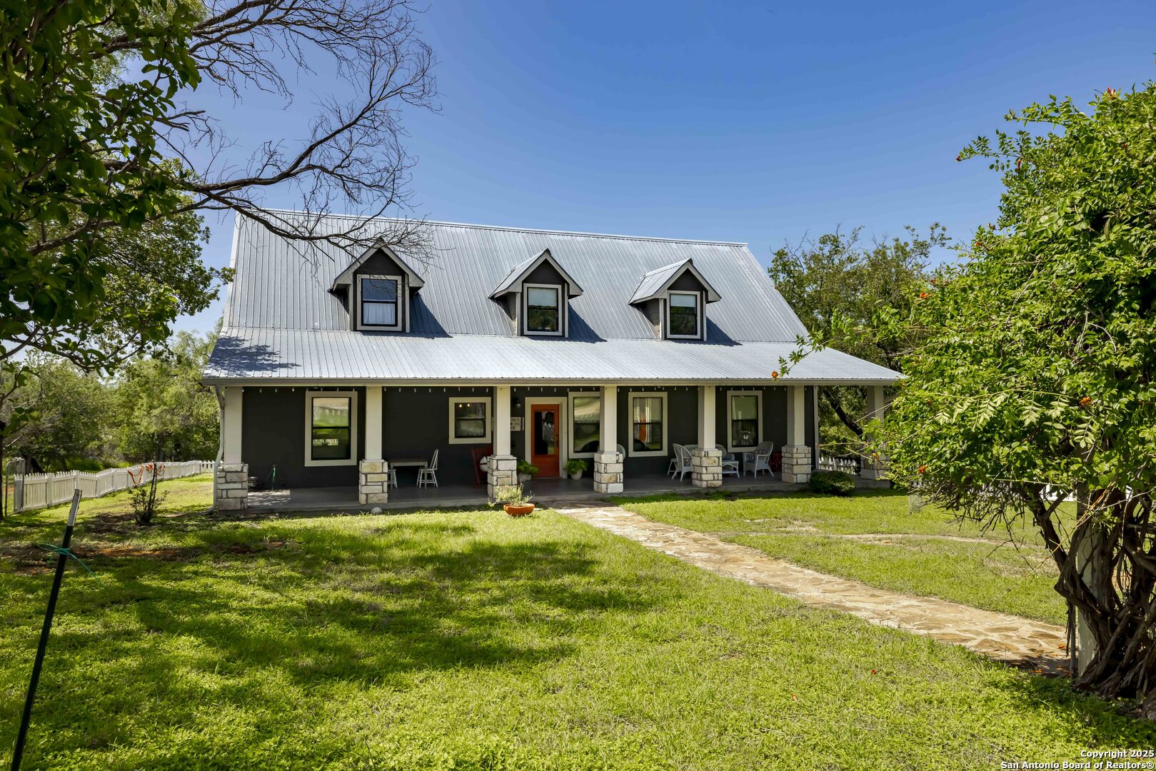 211 Riverside Drive West Llano, TX 78643 - Photo 2 of 74 a view of a white house with a large pool and large trees
