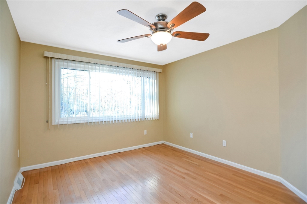 90 Mountain Gate Road, Unit 90 Ashland, MA 01721 - Photo 12 of 29 a view of an empty room with wooden floor and a window