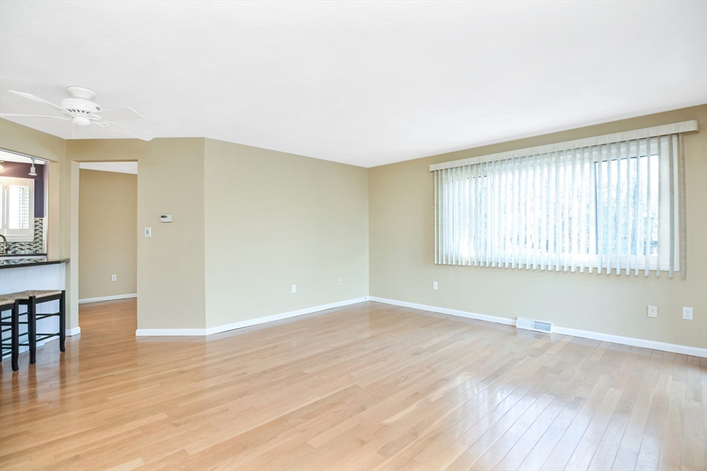 90 Mountain Gate Road, Unit 90 Ashland, MA 01721 - Photo 4 of 29 a view of an empty room with wooden floor and a window