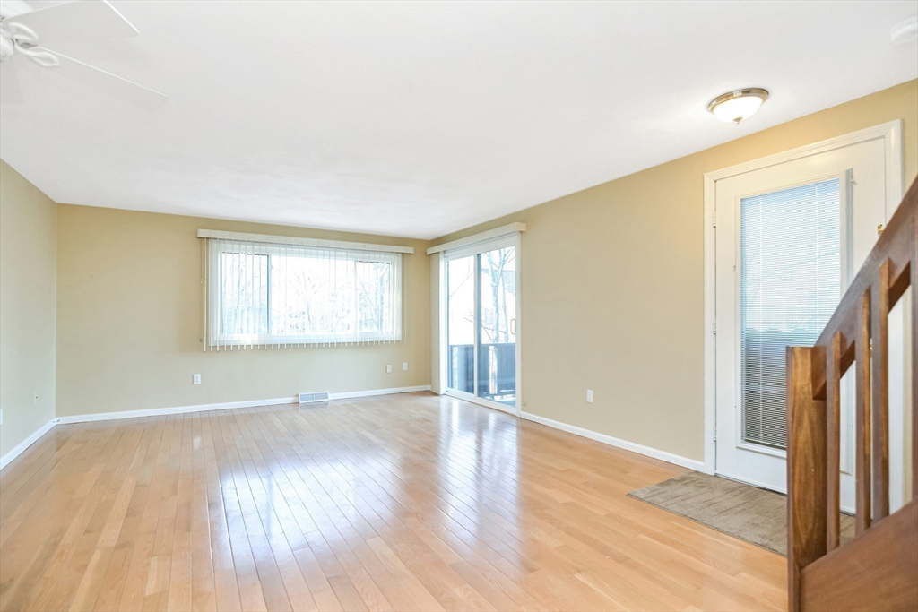 90 Mountain Gate Road, Unit 90 Ashland, MA 01721 - Photo 5 of 29 a view of an empty room with wooden floor and a window