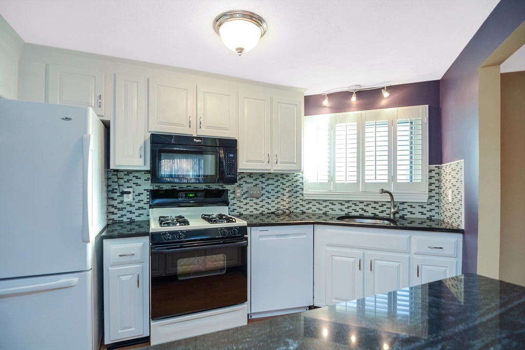 90 Mountain Gate Road, Unit 90 Ashland, MA 01721 - Photo 6 of 29 a kitchen with granite countertop a stove and a refrigerator