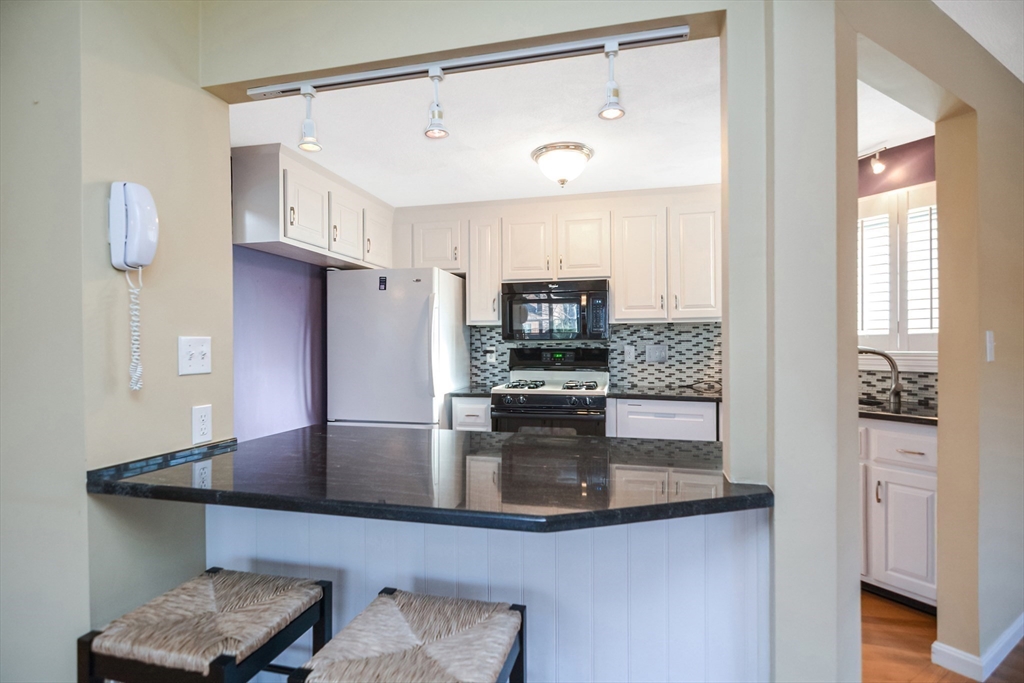 90 Mountain Gate Road, Unit 90 Ashland, MA 01721 - Photo 10 of 29 a kitchen with kitchen island granite countertop a sink cabinets and stainless steel appliances