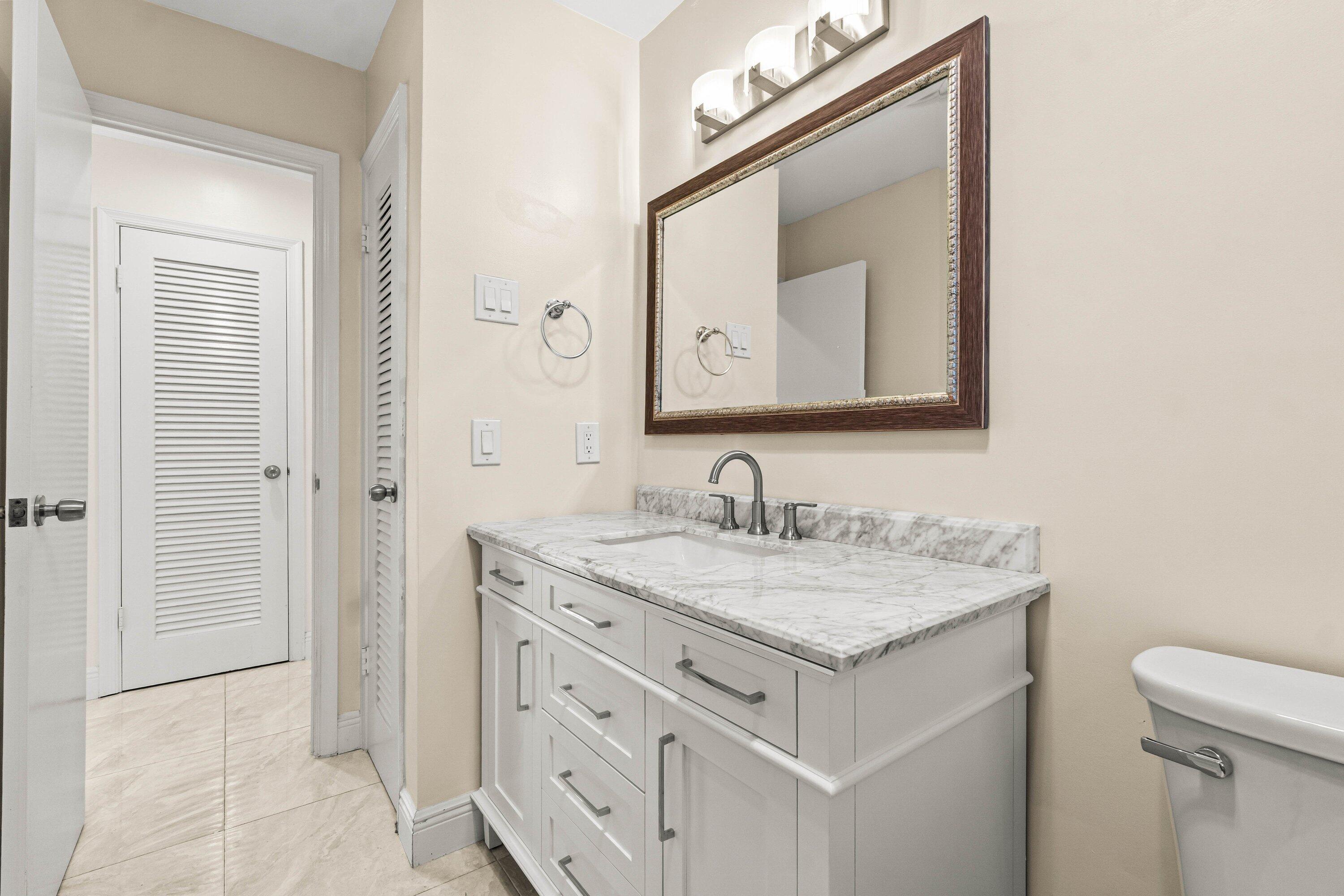 1290 Southwest 8th Street Boca Raton, FL 33486 - Photo 16 of 29 a bathroom with a sink vanity and a mirror