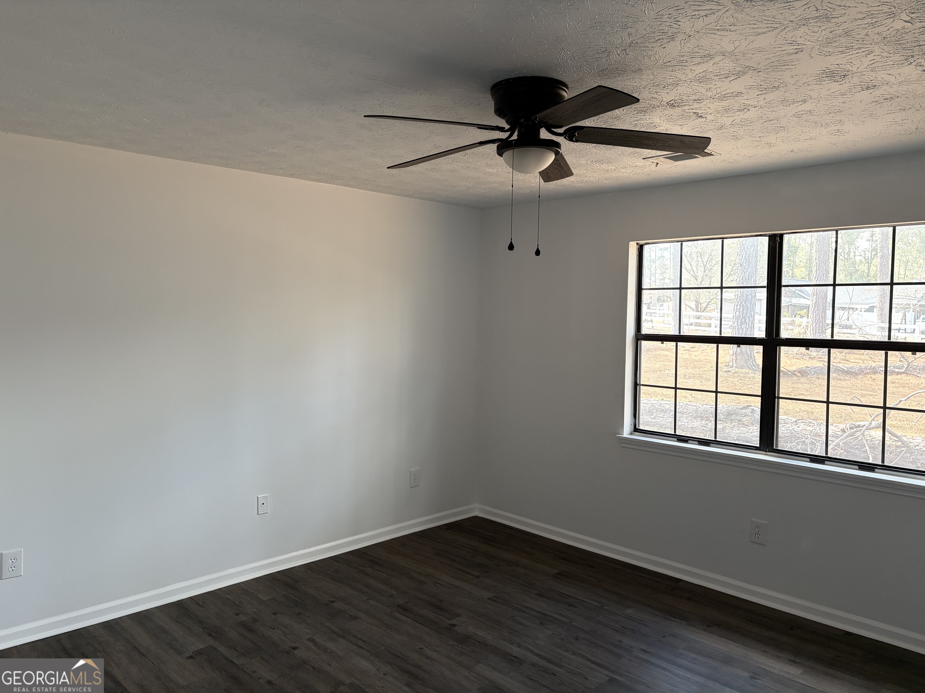 169 Ext N Jefferson Street Lyons, GA 30436 - Photo 13 of 18 a view of an empty room with wooden floor and a window