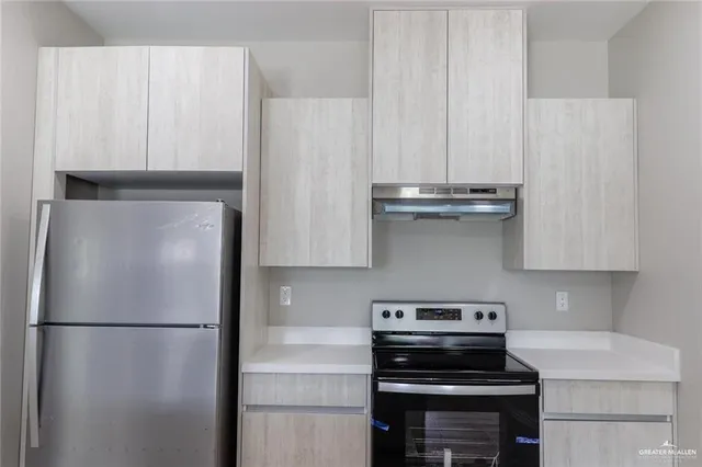 a kitchen with a refrigerator and a stove