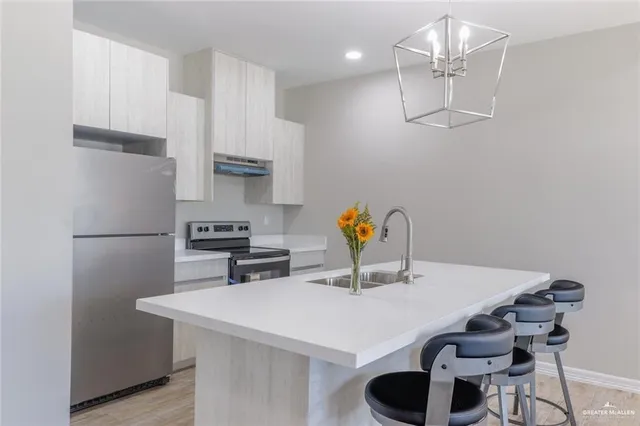 a kitchen with stainless steel appliances a dining table chairs and white cabinets
