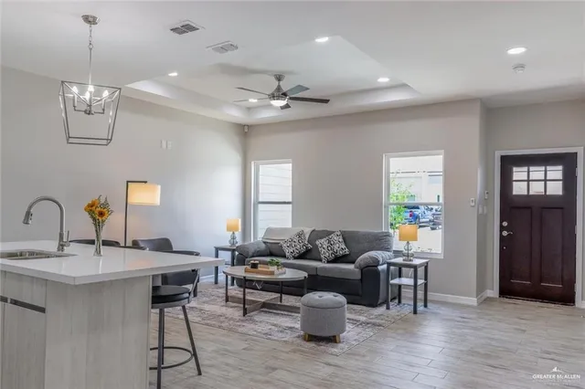 a living room with furniture a chandelier and a dining room