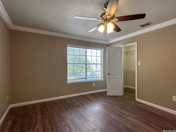 a view of an empty room with window and wooden floor
