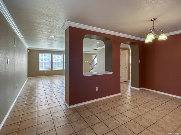 an empty room with kitchen and view of a livingroom