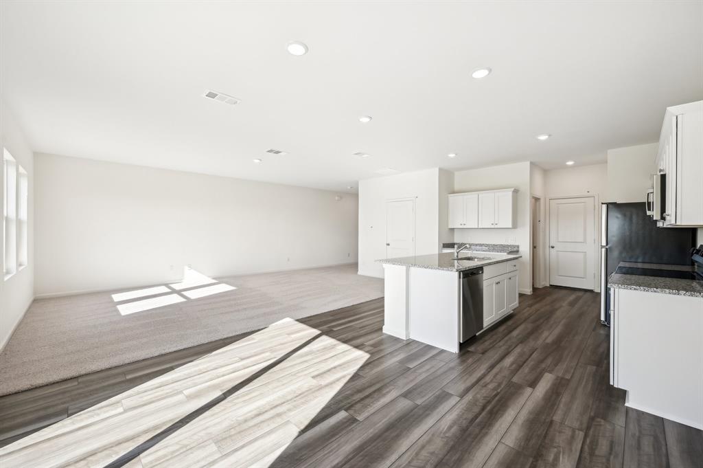 2403 States Street Princeton, TX 75407 - Photo 14 of 39 Kitchen with white cabinetry, recessed lighting, light stone countertops, stainless steel appliances, and a center island with sink