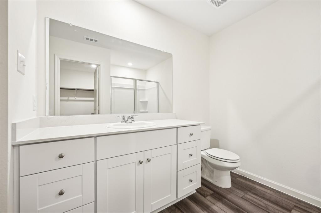 2403 States Street Princeton, TX 75407 - Photo 21 of 39 Full bathroom with vanity, dark wood-style floors, a stall shower, and a spacious closet