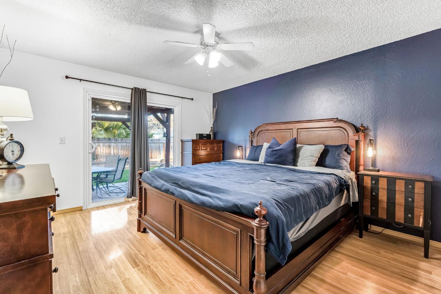3120 West San Ramon Avenue Fresno, CA 93711 - Photo 23 of 36 a bedroom with a large bed a chandelier and dresser