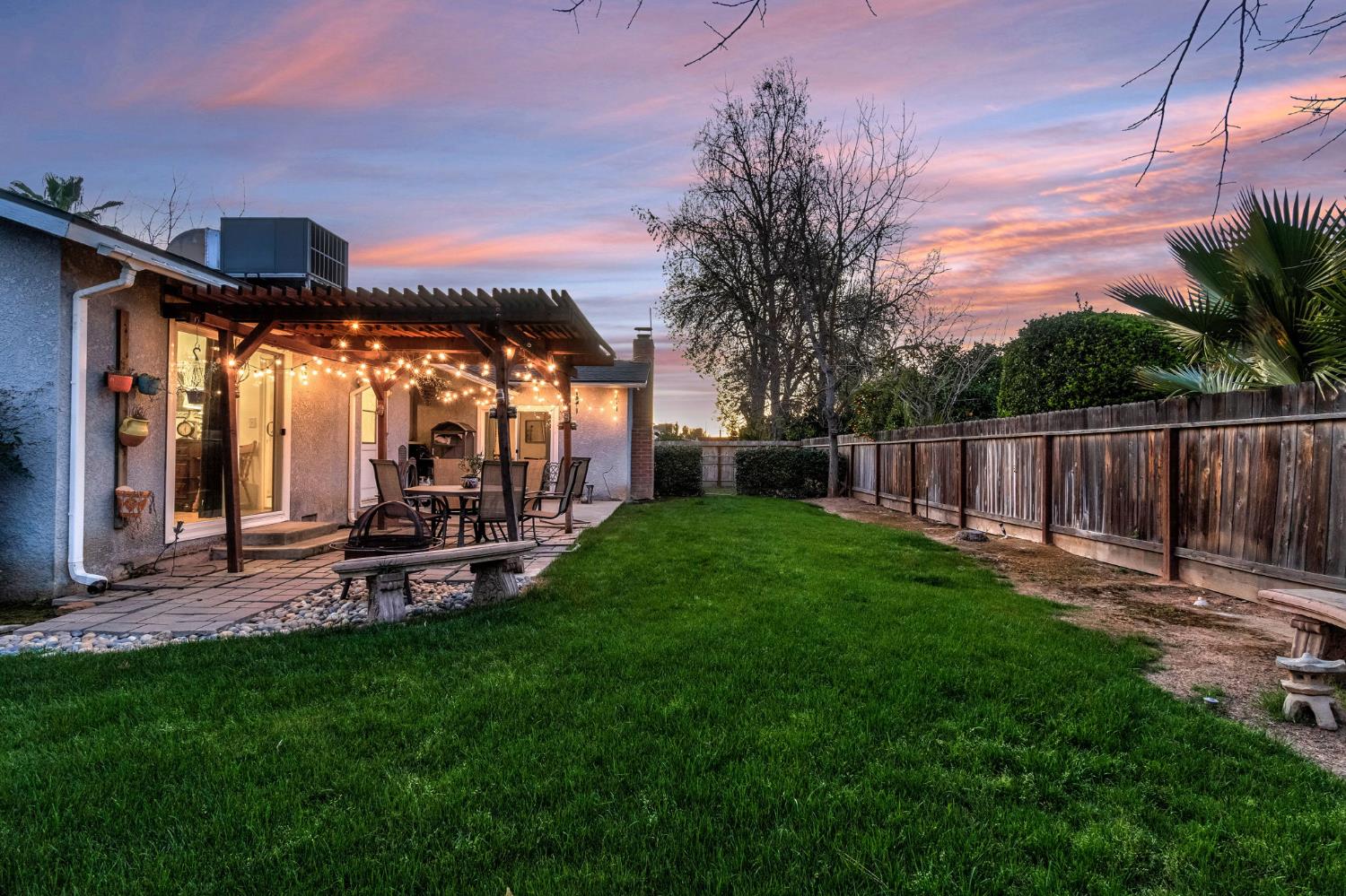 3120 West San Ramon Avenue Fresno, CA 93711 - Photo 31 of 36 a view of a backyard with table and chairs under an umbrella