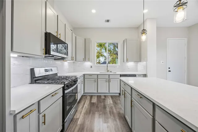 a kitchen with a sink stove top oven and refrigerator