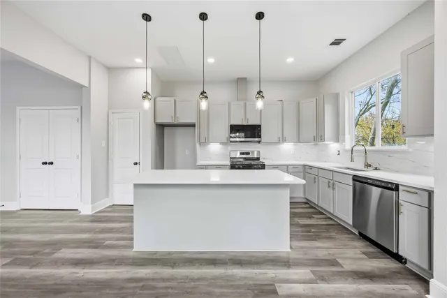 a large kitchen with stainless steel appliances kitchen island granite countertop a granite counter tops and a view of living room