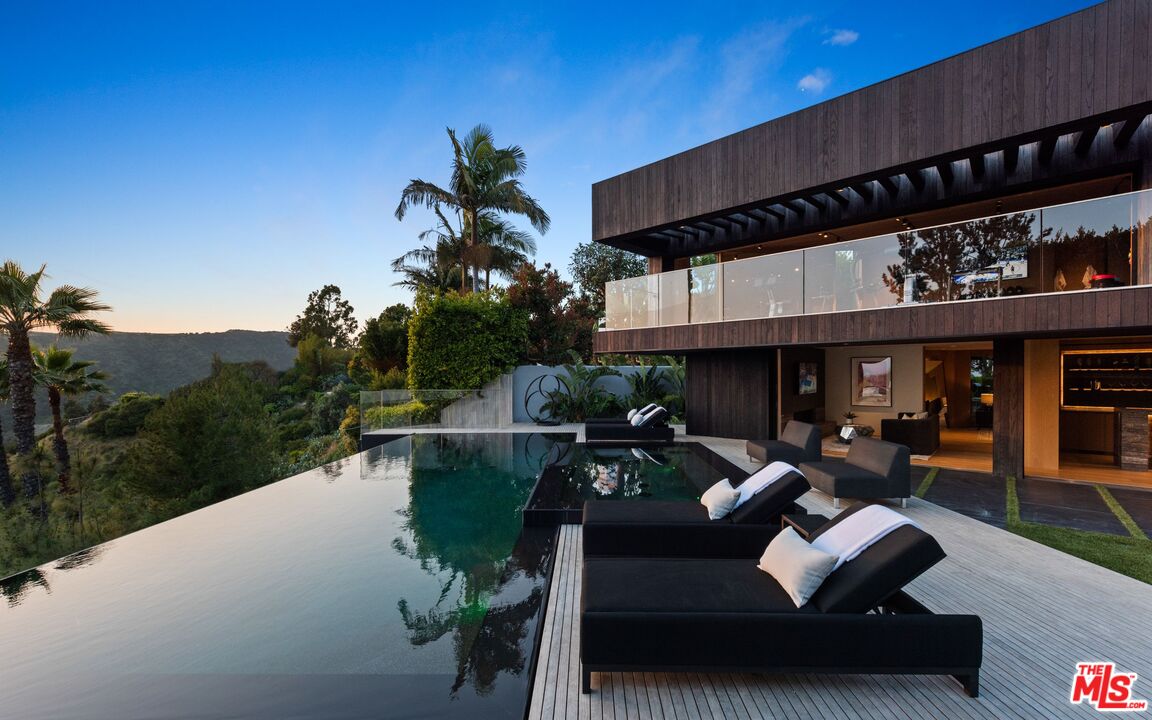 1663 Summitridge Drive Beverly Hills, CA 90210 - Photo 17 of 41 a view of a patio with couches table and chairs with potted plants