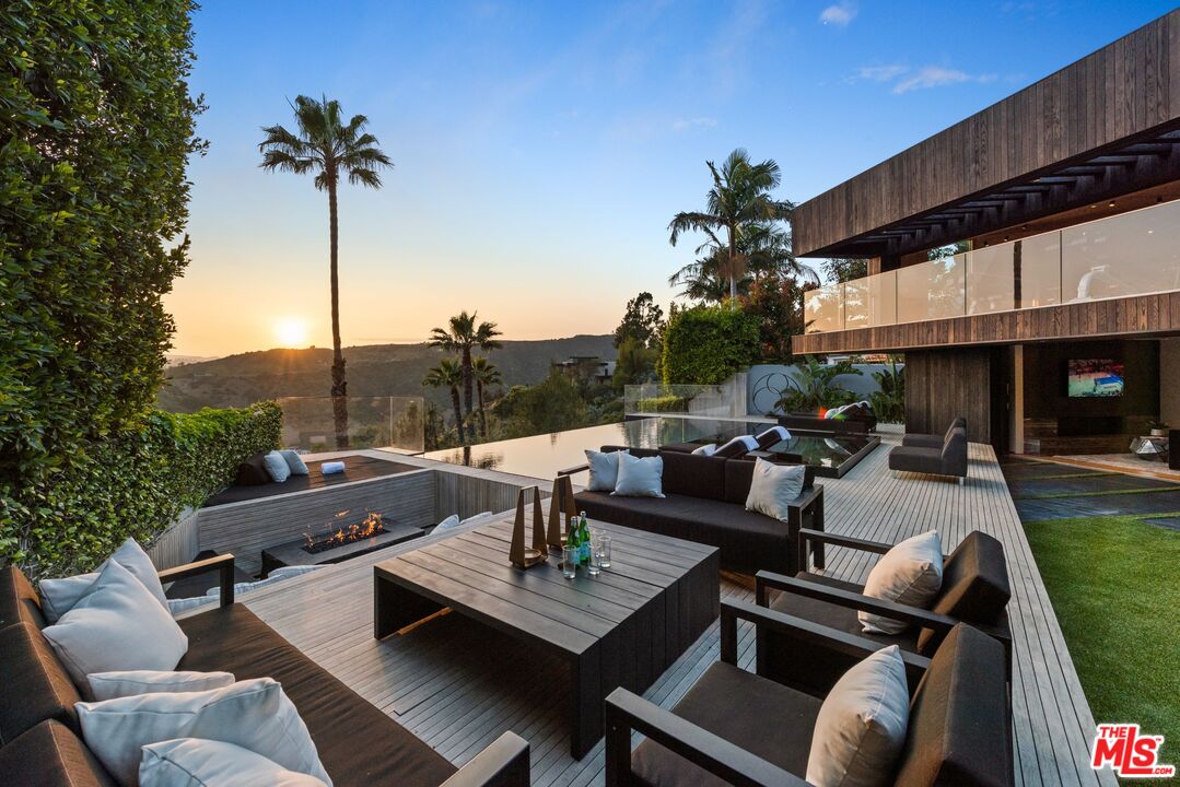 1663 Summitridge Drive Beverly Hills, CA 90210 - Photo 21 of 41 a view of a patio with couches and a table and chairs with garden view