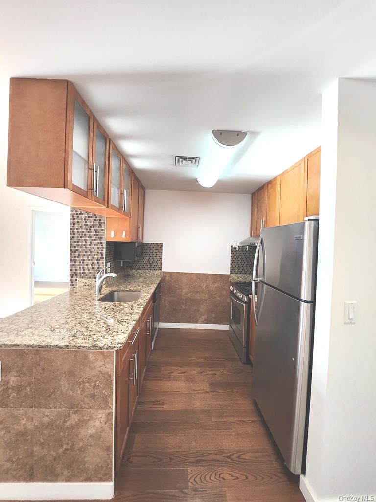 40-26 College Point Boulevard, Unit 18K Queens, NY 11354 - Photo 2 of 16 a kitchen with stainless steel appliances granite countertop a refrigerator and a sink