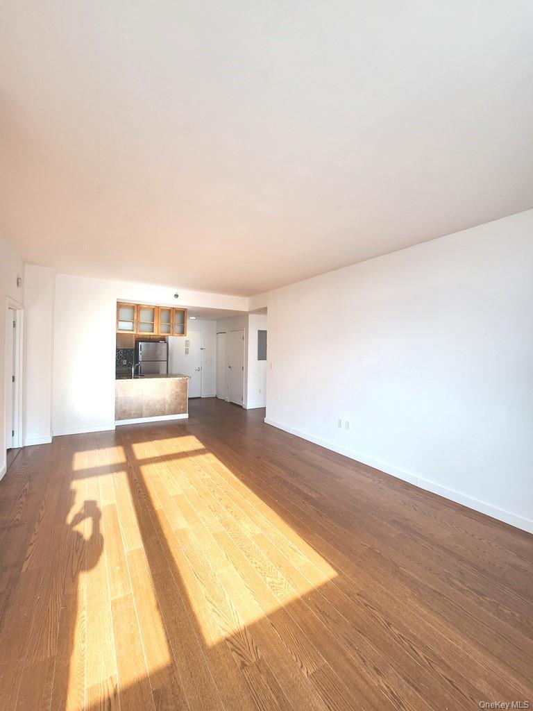 40-26 College Point Boulevard, Unit 18K Queens, NY 11354 - Photo 4 of 16 a bedroom with a bed and closet with wooden floor