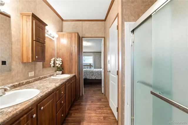 a en suite bathroom with a granite countertop double vanity sink and a mirror