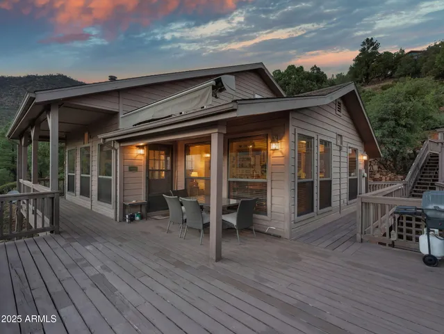 a front view of house with deck outdoor seating and yard