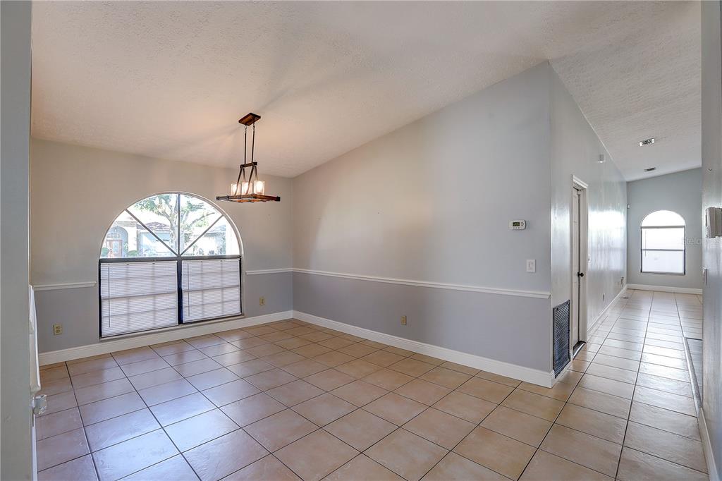 1418 Buckner Road Valrico, FL 33596 - Photo 6 of 37 an empty room with windows and chandelier