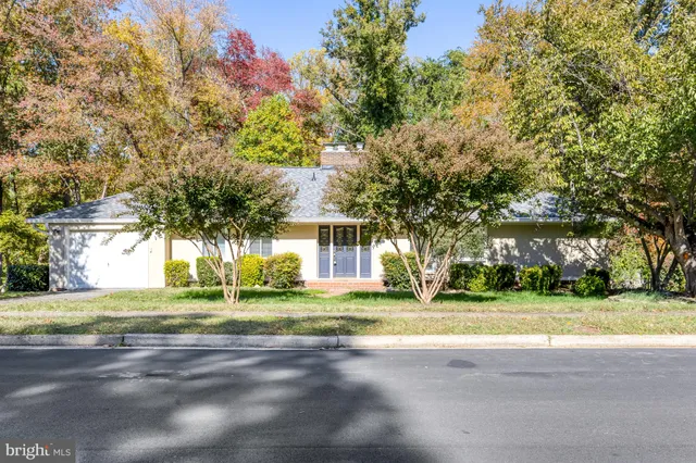 a view of a house with a big yard and large trees
