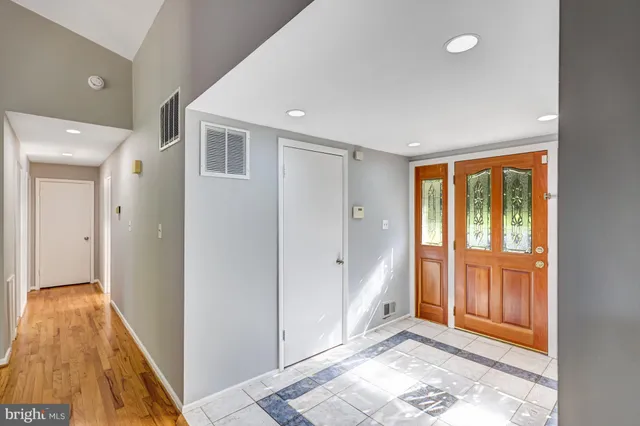a view of entryway with wooden floor and cabinet