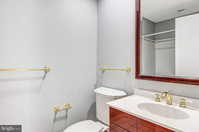 a bathroom with a sink mirror vanity and toilet
