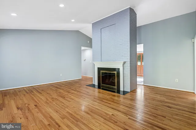 a view of empty room with wooden floor and fireplace